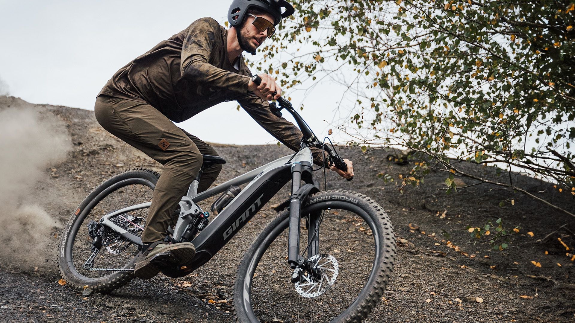 Mountain biker riding down a steep slope with his favourite mtb pants. Cover image for a guide about how to choose your next MTB pants.